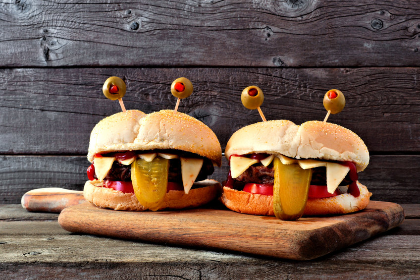 Halloween monster hamburgers on a paddle board against an old wood